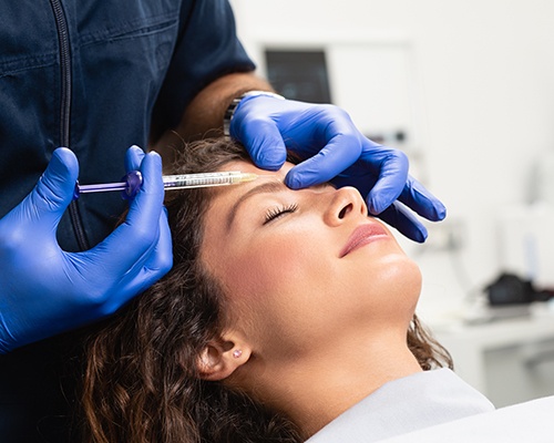 Woman receiving BOTOX injection between her eyebrows