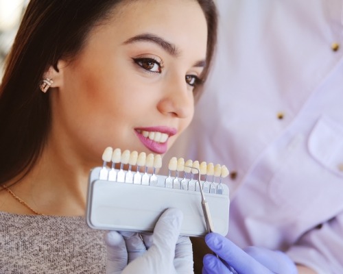 Young woman trying on veneers while visiting cosmetic dentist in Jenks