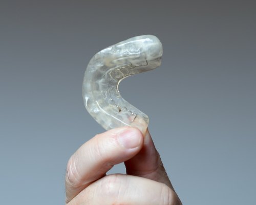 Person holding a dental nightguard in their hand